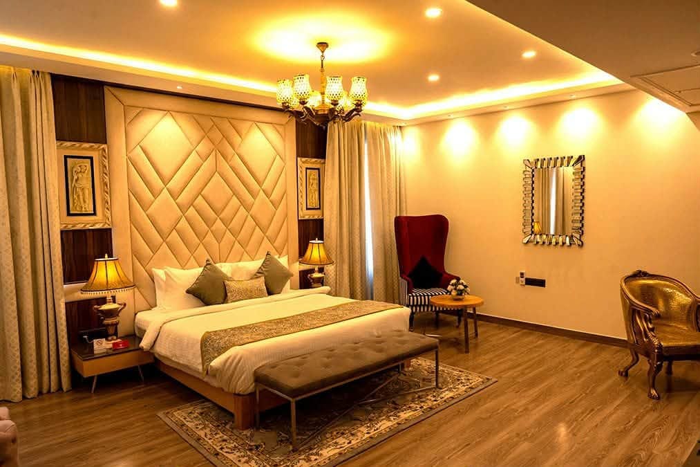 Luxury Suite with king bed and chandelier at Mahakal Bhakta Nivas